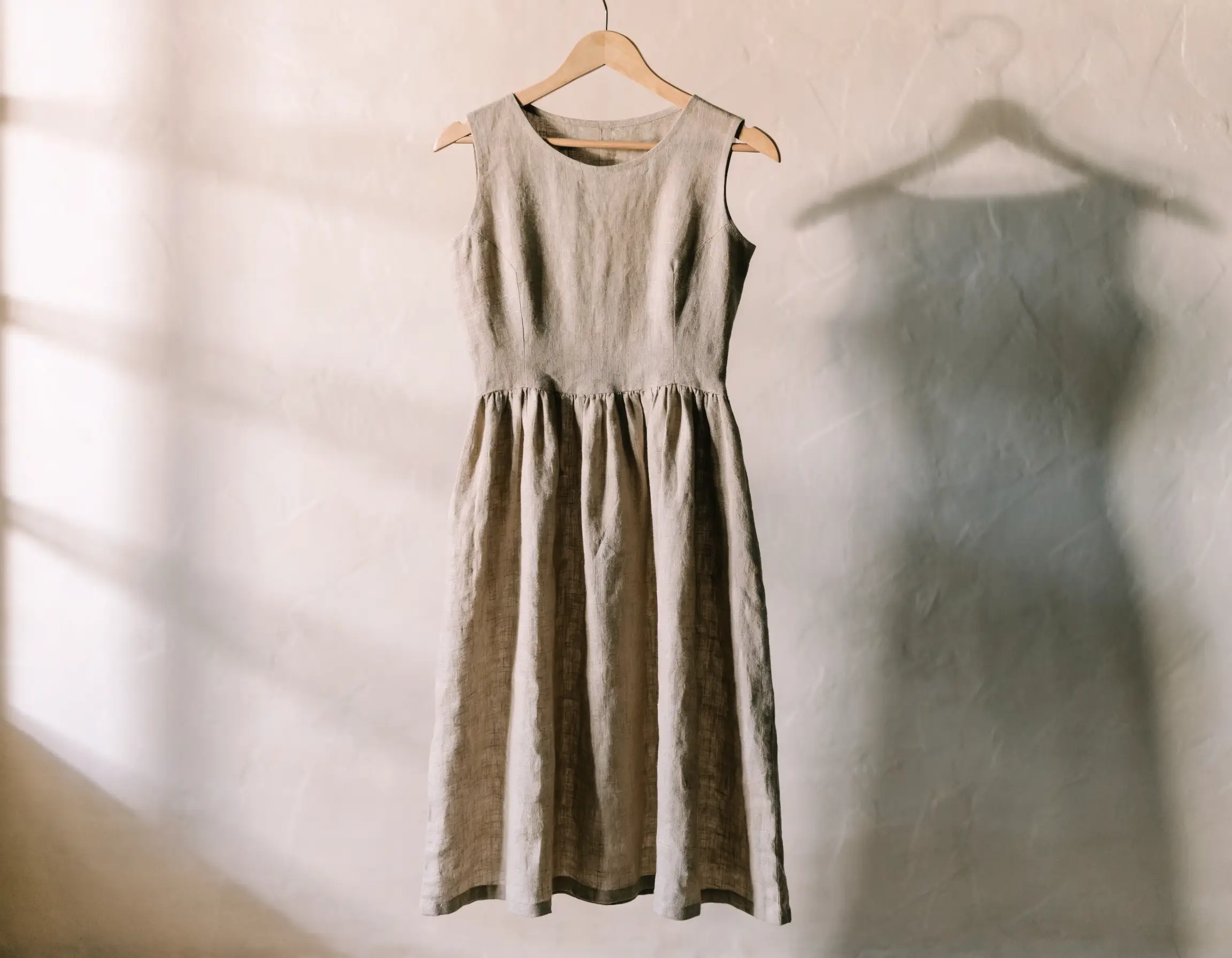 A linen dress on a wooden hanger — the kind of item WorthScout scans for a resale verdict